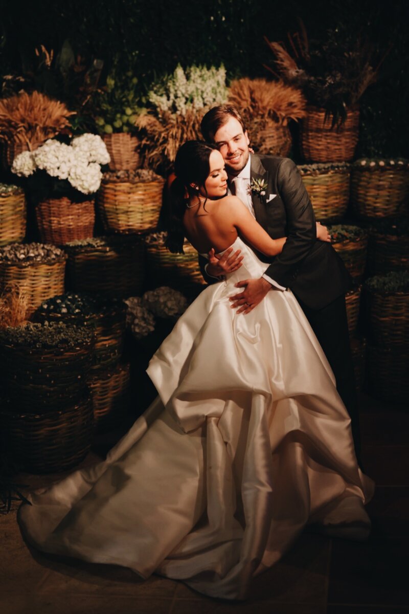 Bruna e João Felipe: noivos com decoração de casamento rústica ao fundo