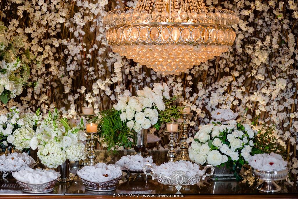 Decoração com flores brancas e lustres para mesa de doces