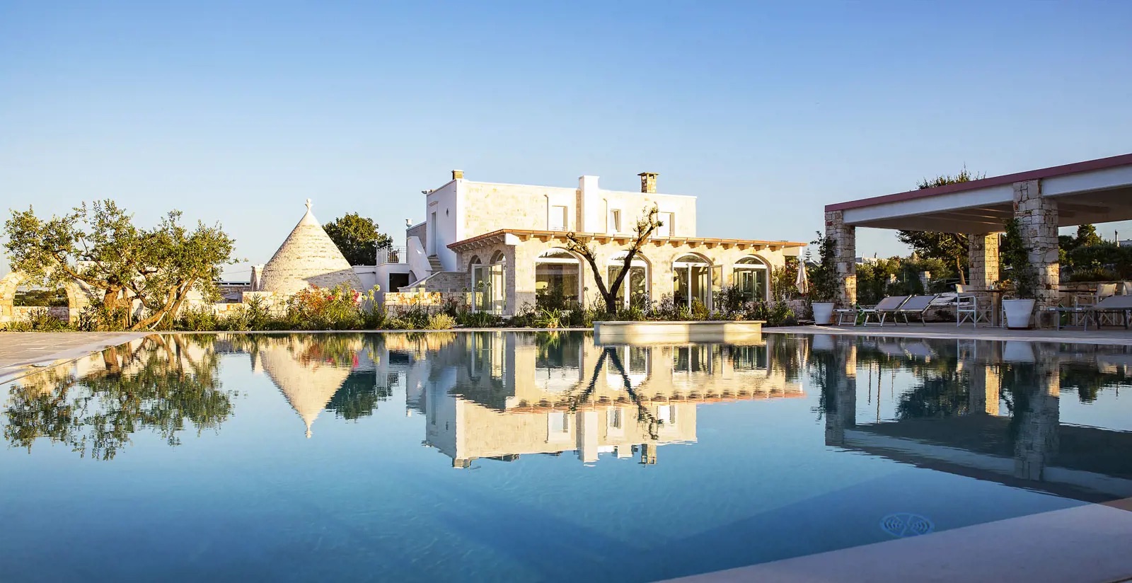 Em Locorotondo, o resort foi restaurado a partir de trulli do século XVI e conta com jardins, masseria e uma antiga adega transformada em piscina subterrânea.