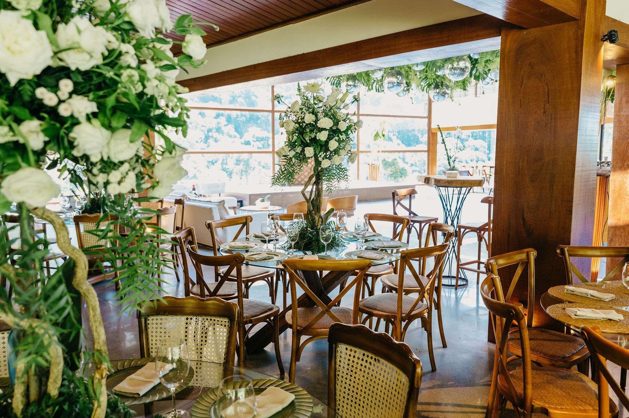 Mesas de convidados decoradas em ambiente interno com elementos em madeira | Foto: 2Barcos