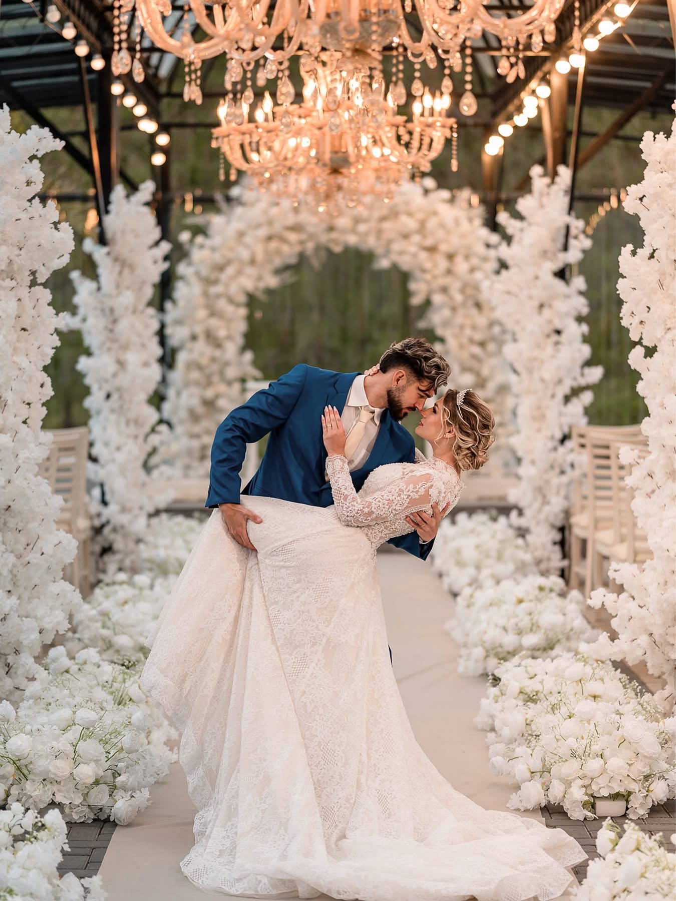 Casal posa entre flores brancas na Tenda de Cristal | Foto: Acervo local