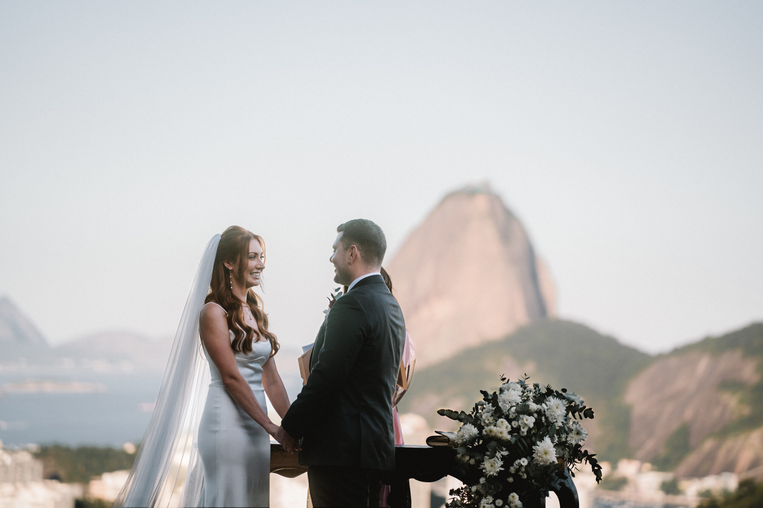 Noivos durante cerimônia na Mansão Alvite, com Pão de Açúcar ao fundo, no Rio | Foto: LoveShake