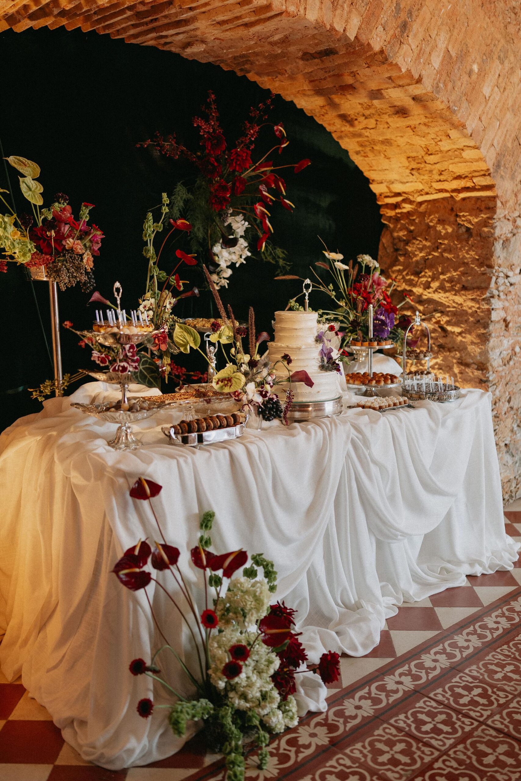 Mesa de doces combina flores intensas, bolo branco e louças clássicas | Foto: Acervo local