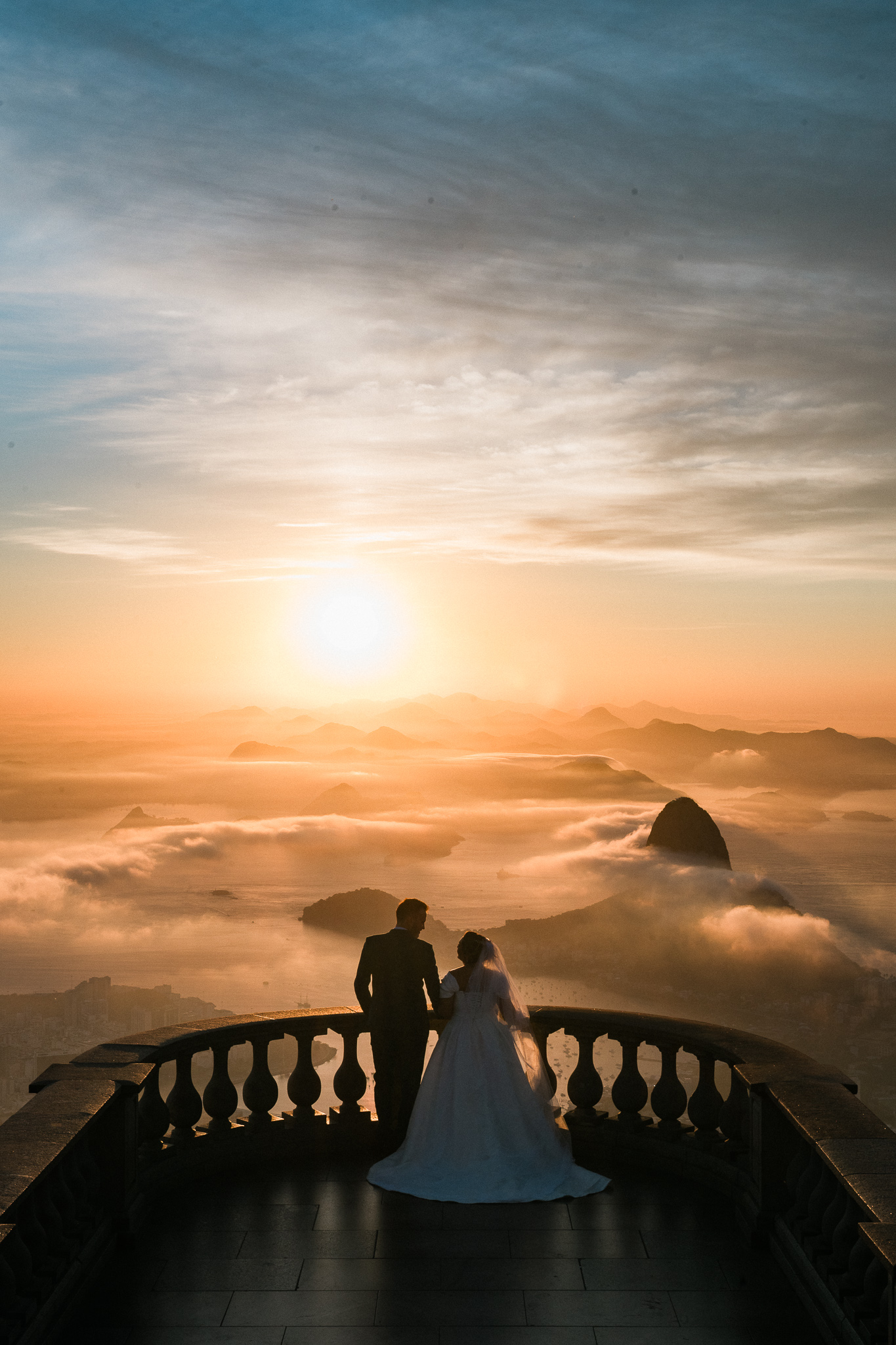 Casal contempla o pôr do sol e a paisagem do Rio do alto do Corcovado | Foto: Claudio Azevedo