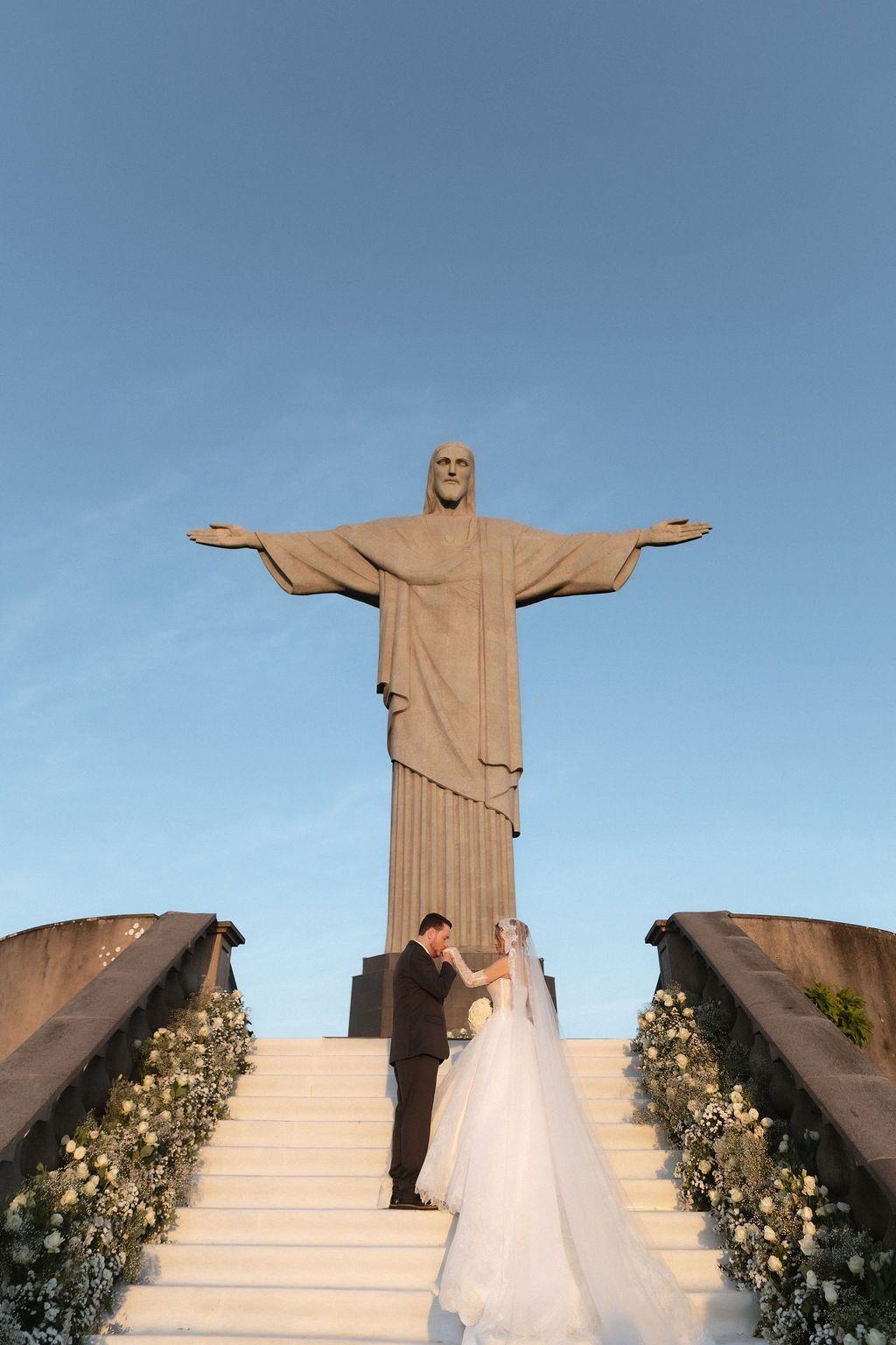 Noivos trocam um gesto de carinho diante do Cristo Redentor | Foto: Venamori Fotografia