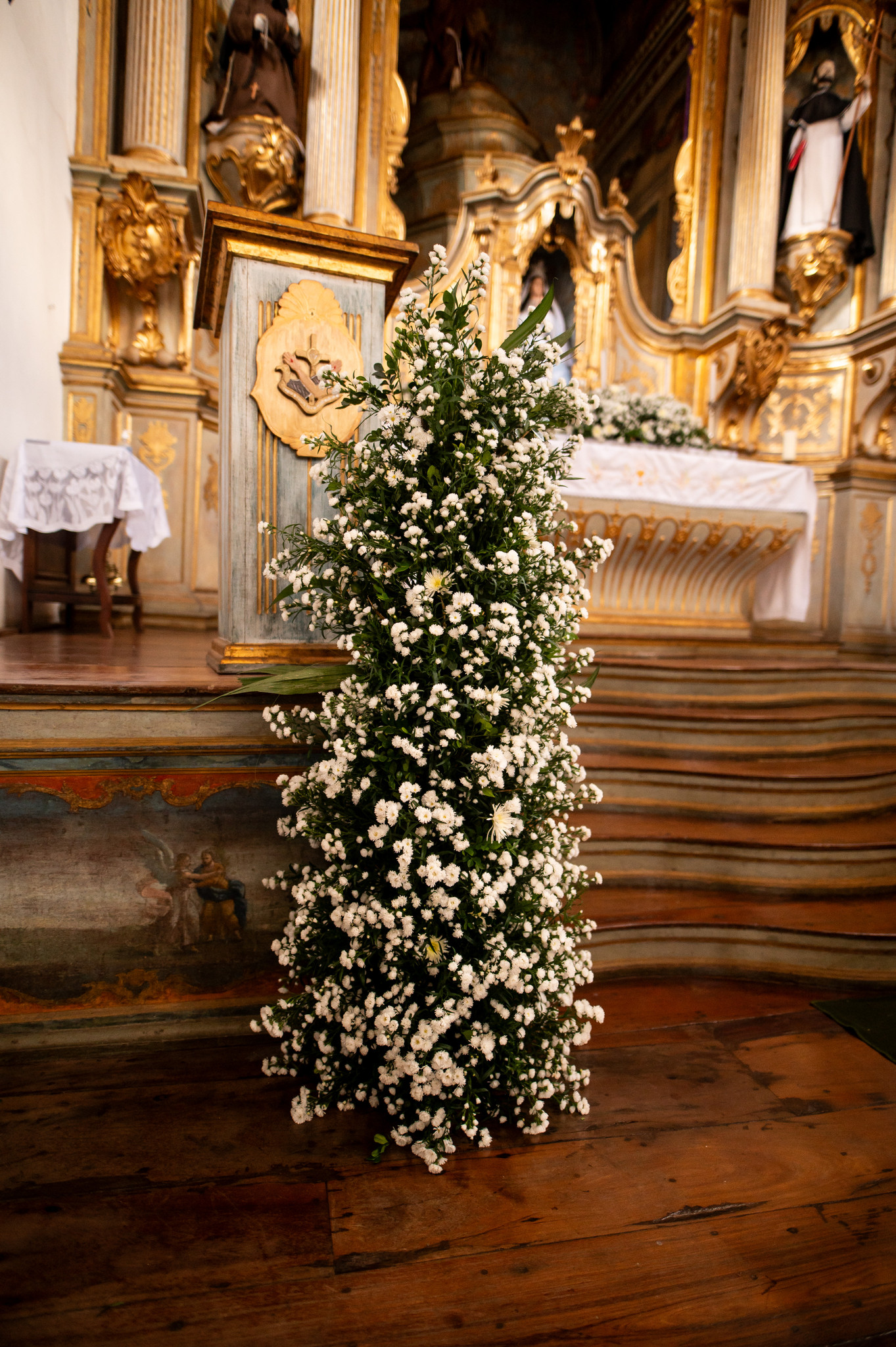 Arranjo floral branco compõe a decoração de cerimônia religiosa em Diamantina | Foto: Gui Soares